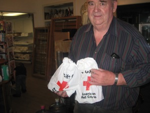 Bill Mix receives some much need comfort from the Red Cross as he busily works to salvage his business and rentals.